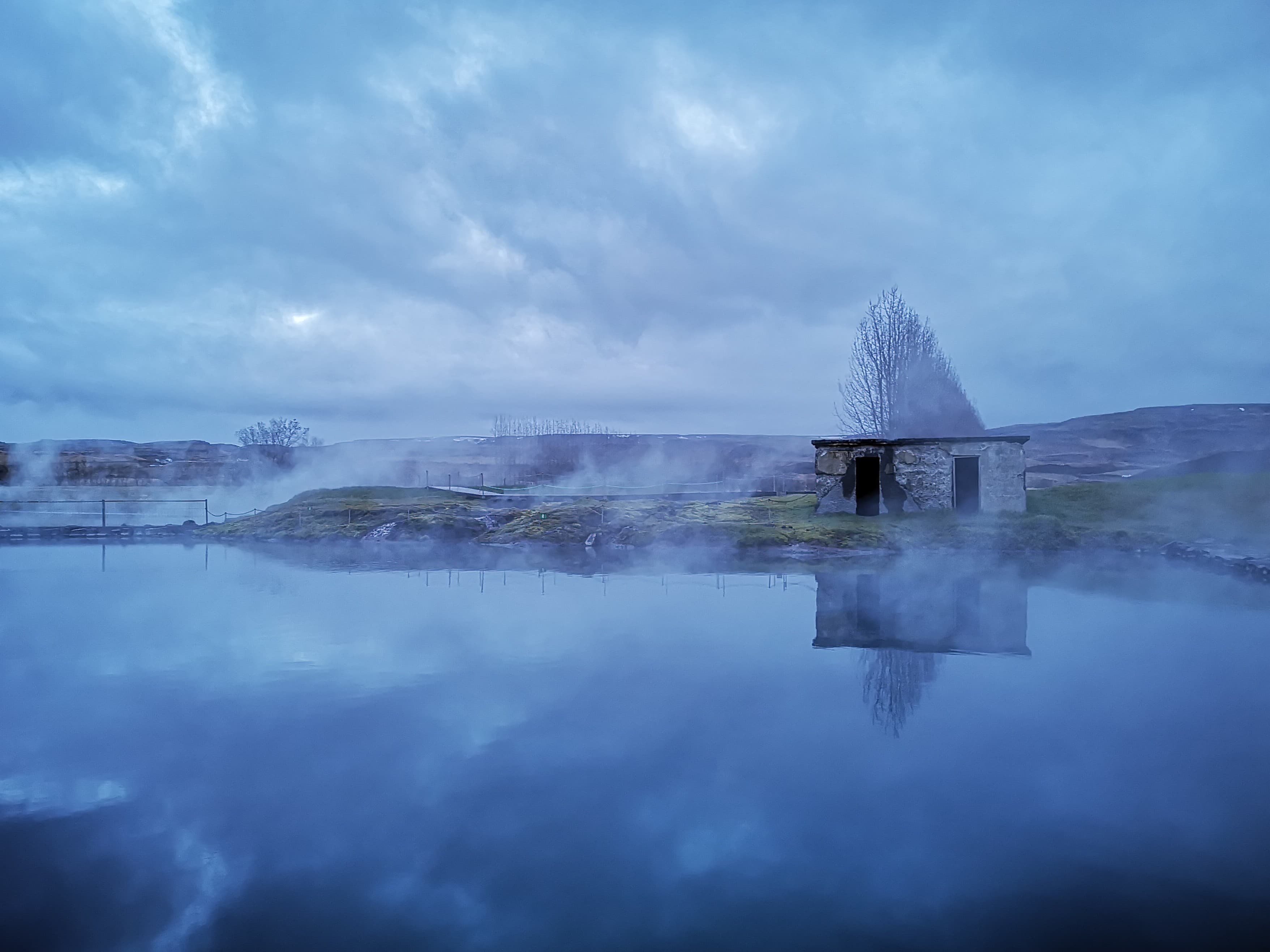 The Secret Lagoon geothermal pool surrounded by steam in Flúðir, Iceland